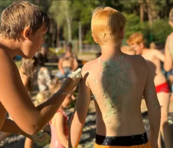 Dzieci malują się kolorowymi farbami podczas sensoplastyki na plaży w Dzikiej Ochli
